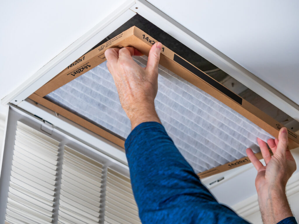 HVAC technician replacing a home air filter in Daly City