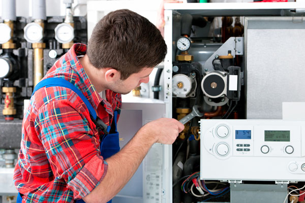 Heating technician repairing boiler controls in Daly City