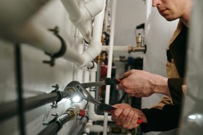 Technician inspecting commercial plumbing pipes in Daly City