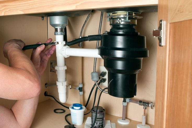 Plumber repairing a garbage disposal in Daly City