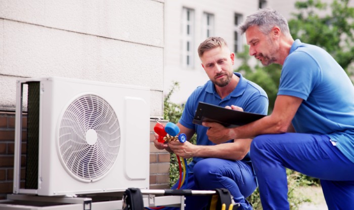 HVAC technicians installing an outdoor air conditioning unit in Daly City