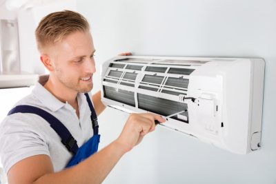HVAC technician maintaining a ductless air conditioner in Daly City