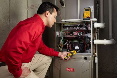 Heating technician diagnosing a furnace repair in Daly City